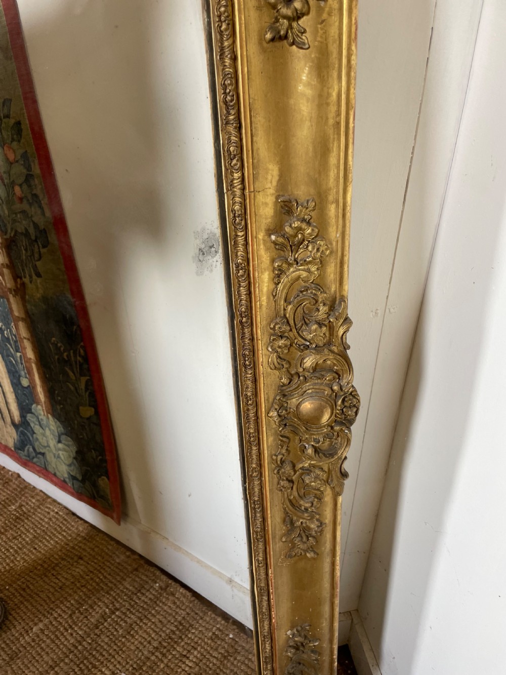 A large early 19th-century rectangular overmantle mirror with a detailed gold leaf frame featuring carved acanthus motifs and a central crest. View VI