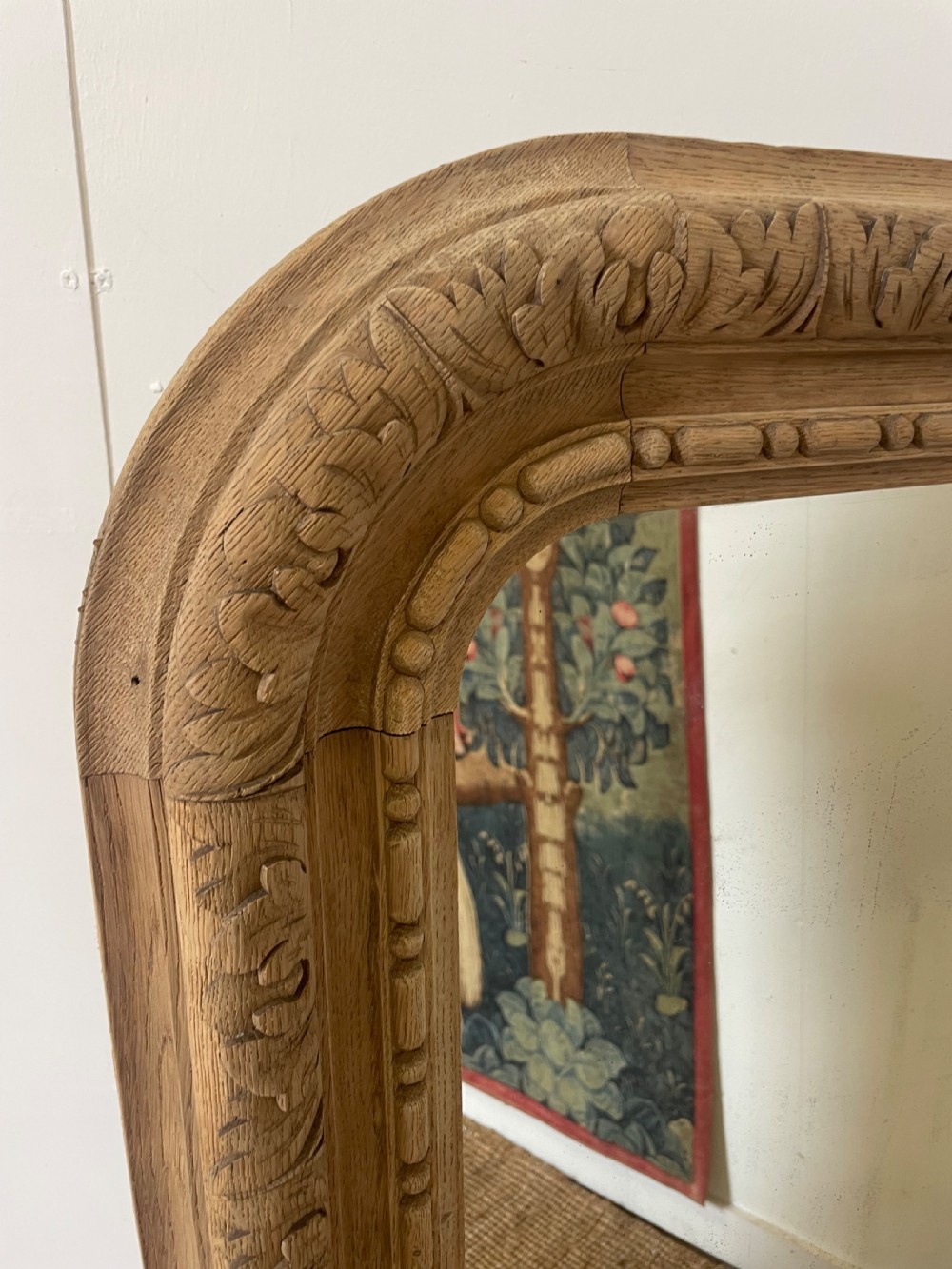 An upright 19th-century carved oak wall mirror with rounded top corners and continuous foliate carved frame detailing. View II