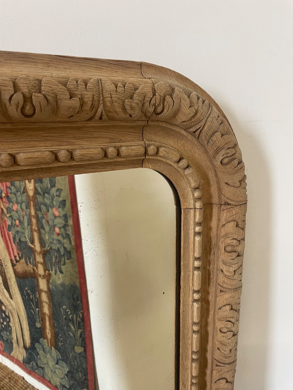 An upright 19th-century carved oak wall mirror with rounded top corners and continuous foliate carved frame detailing. View IV