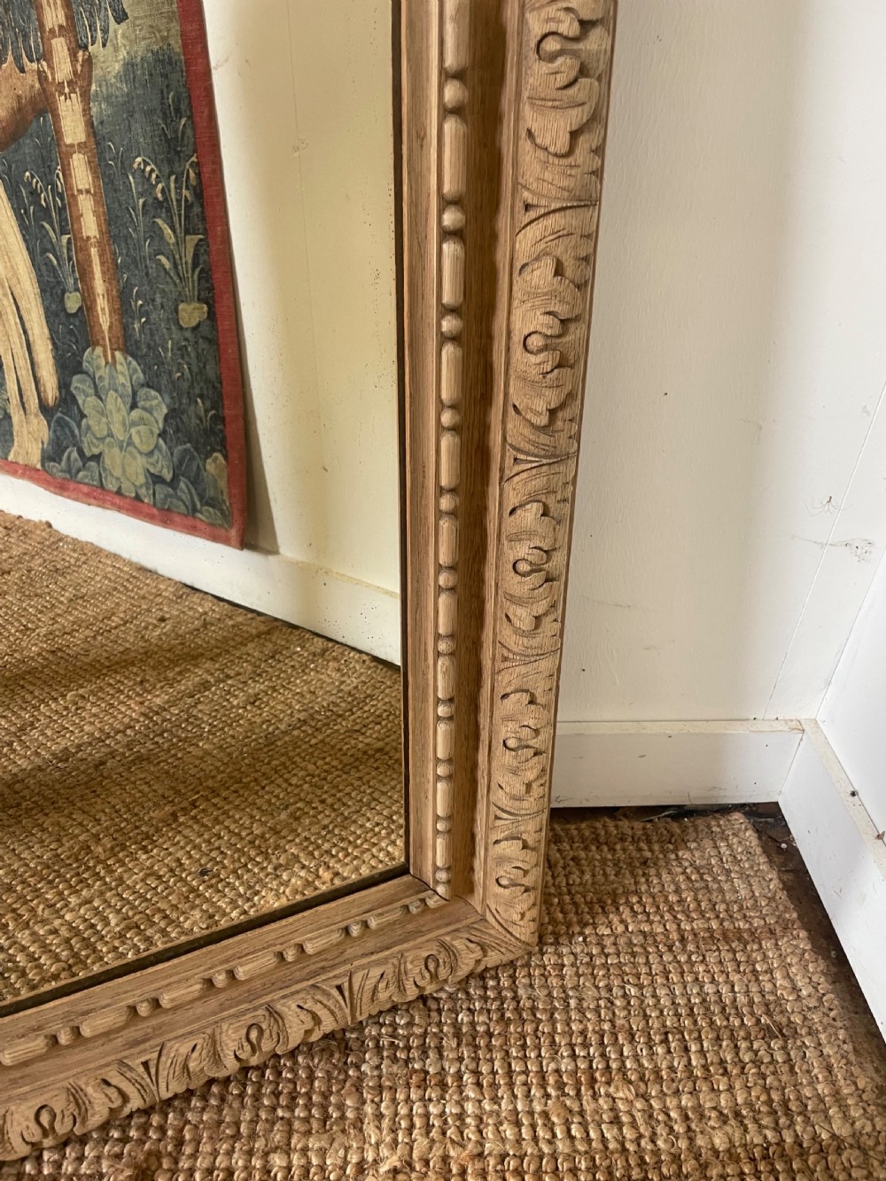 An upright 19th-century carved oak wall mirror with rounded top corners and continuous foliate carved frame detailing. View V