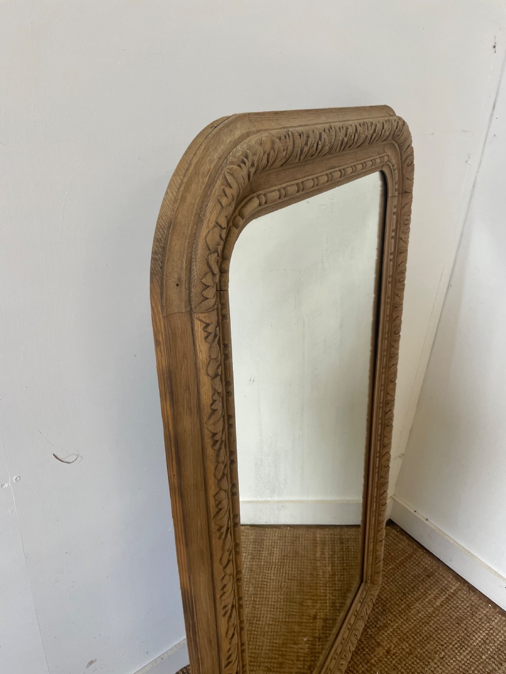 An upright 19th-century carved oak wall mirror with rounded top corners and continuous foliate carved frame detailing. View IX