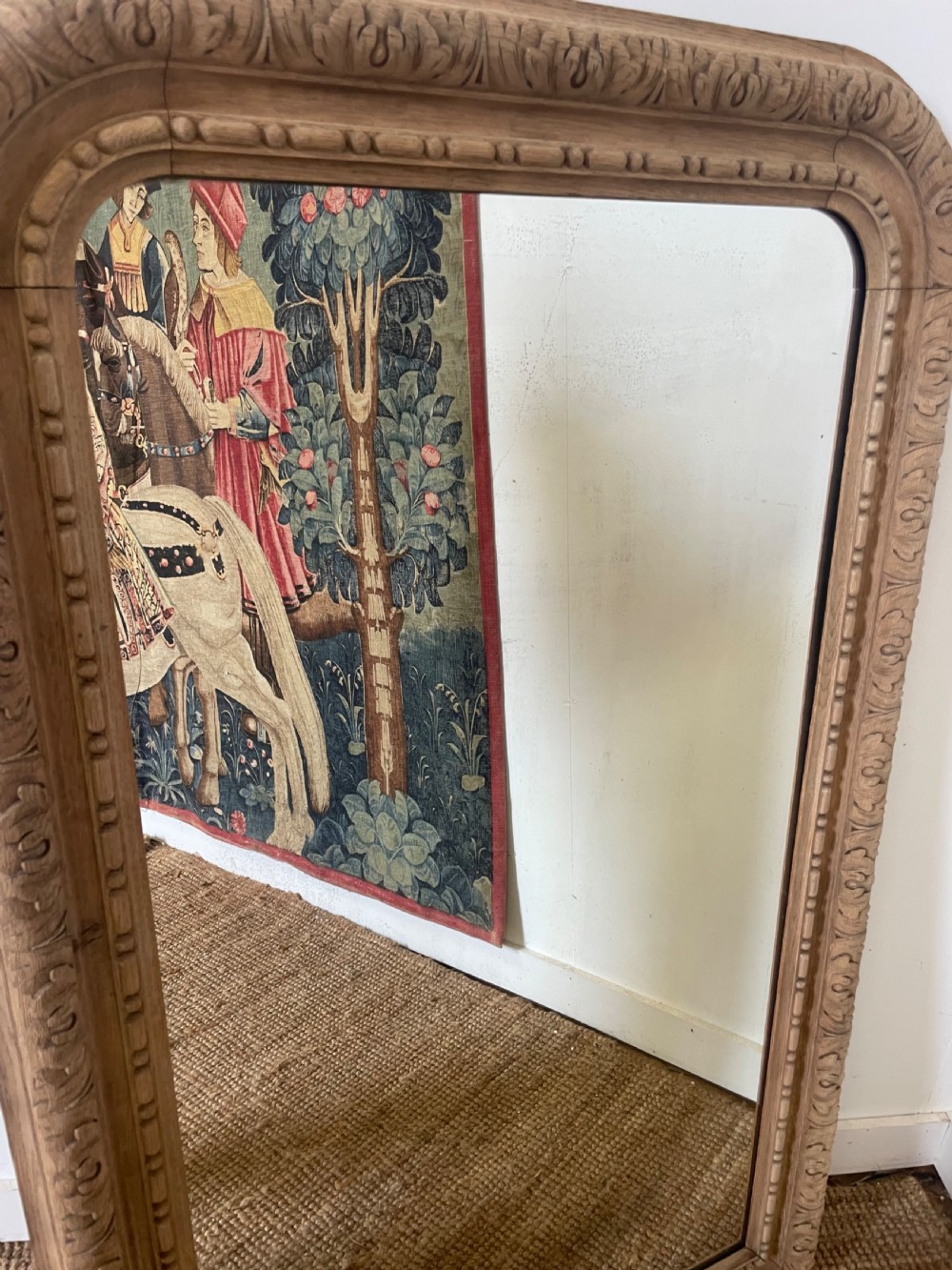 An upright 19th-century carved oak wall mirror with rounded top corners and continuous foliate carved frame detailing. View X