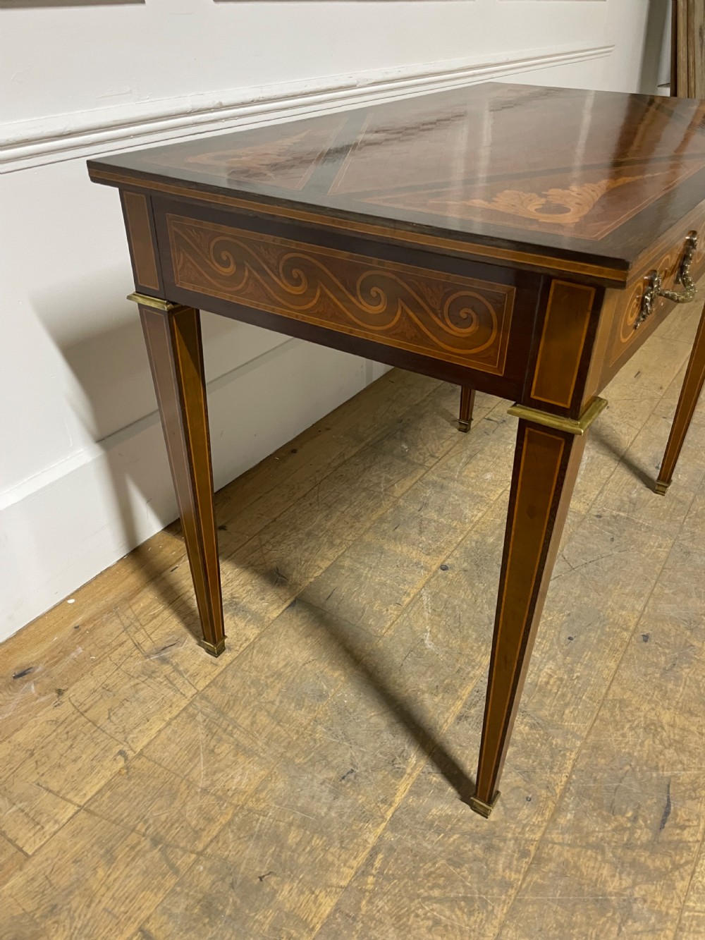 A rectangular antique wooden writing table featuring intricate geometric and floral marquetry on the top and frieze drawer, accented with cast brass mounts and tapering legs. View III