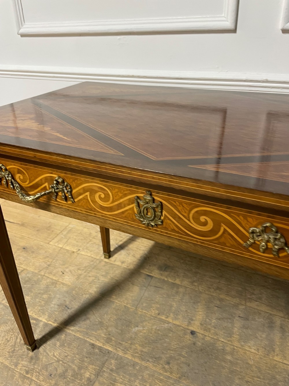 A rectangular antique wooden writing table featuring intricate geometric and floral marquetry on the top and frieze drawer, accented with cast brass mounts and tapering legs. View IX
