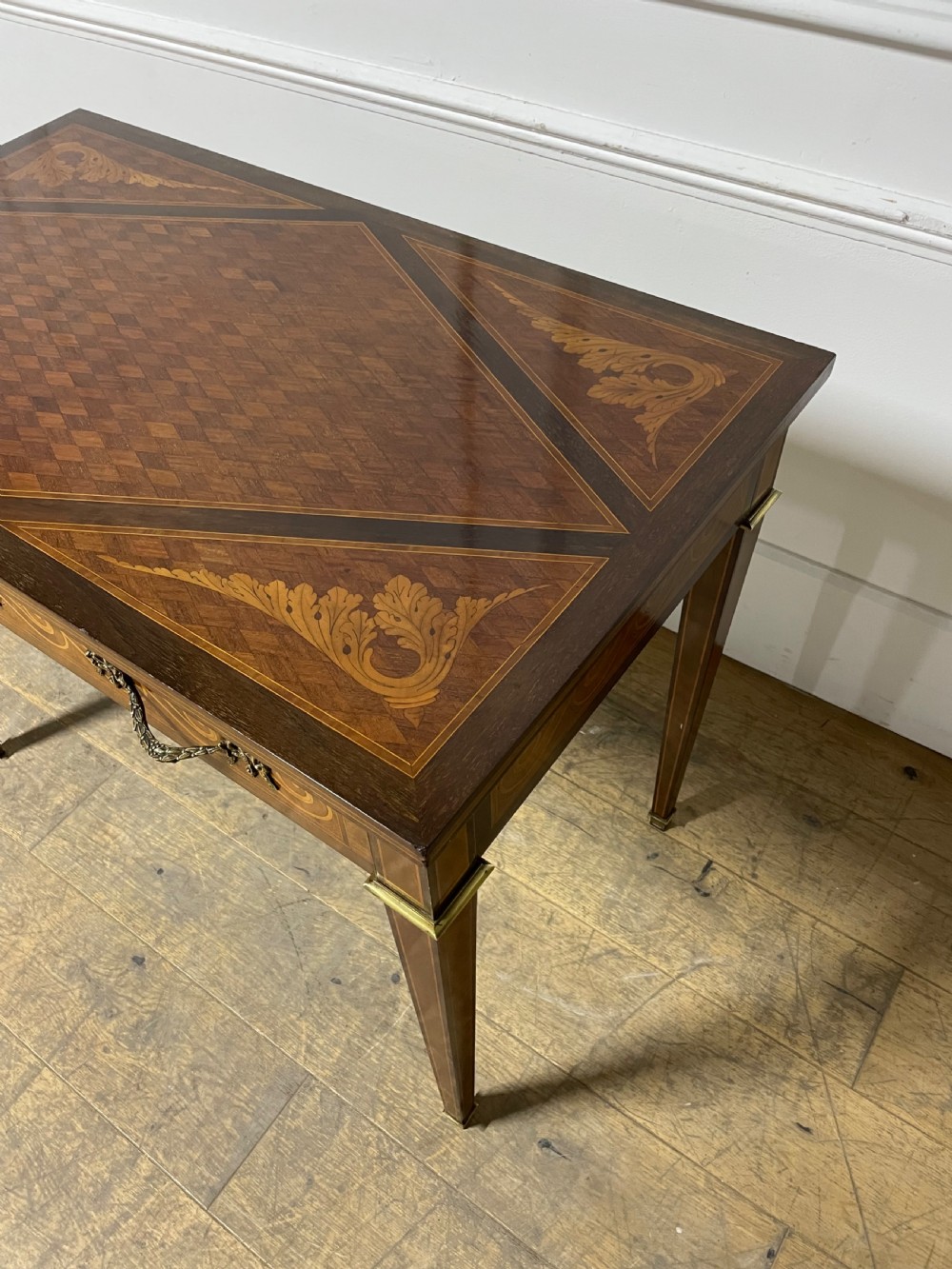 A rectangular antique wooden writing table featuring intricate geometric and floral marquetry on the top and frieze drawer, accented with cast brass mounts and tapering legs. View XII