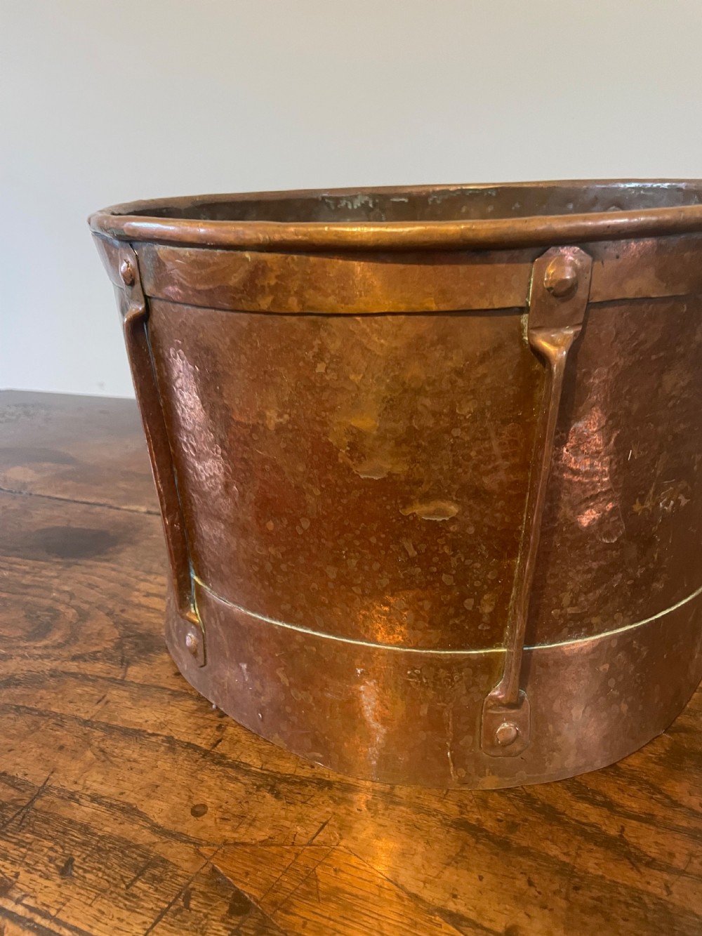 Nineteenth-century hand-hammered copper ferrat bucket featuring riveted vertical support straps and twin side handles. View III