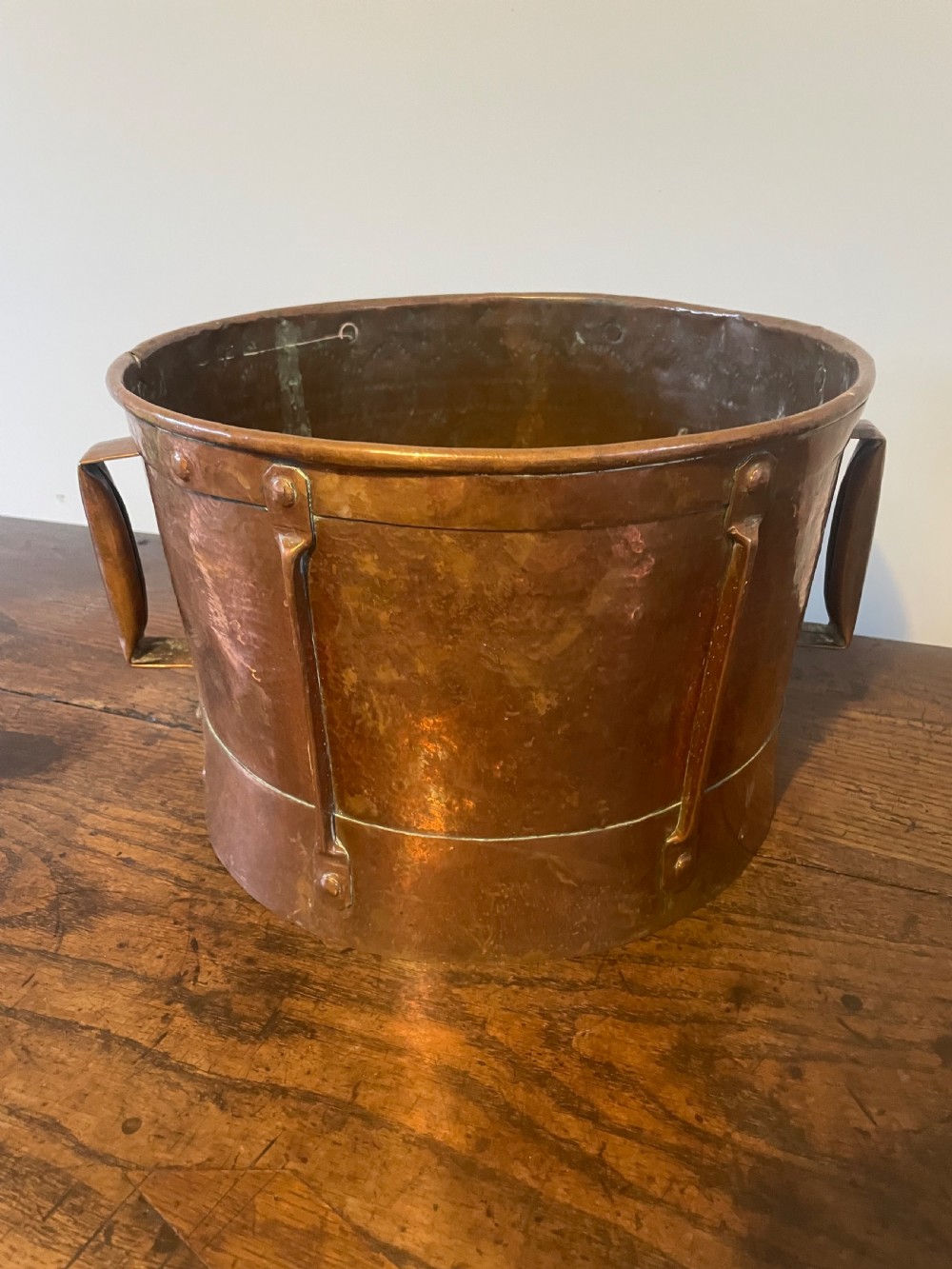 Nineteenth-century hand-hammered copper ferrat bucket featuring riveted vertical support straps and twin side handles. View VII