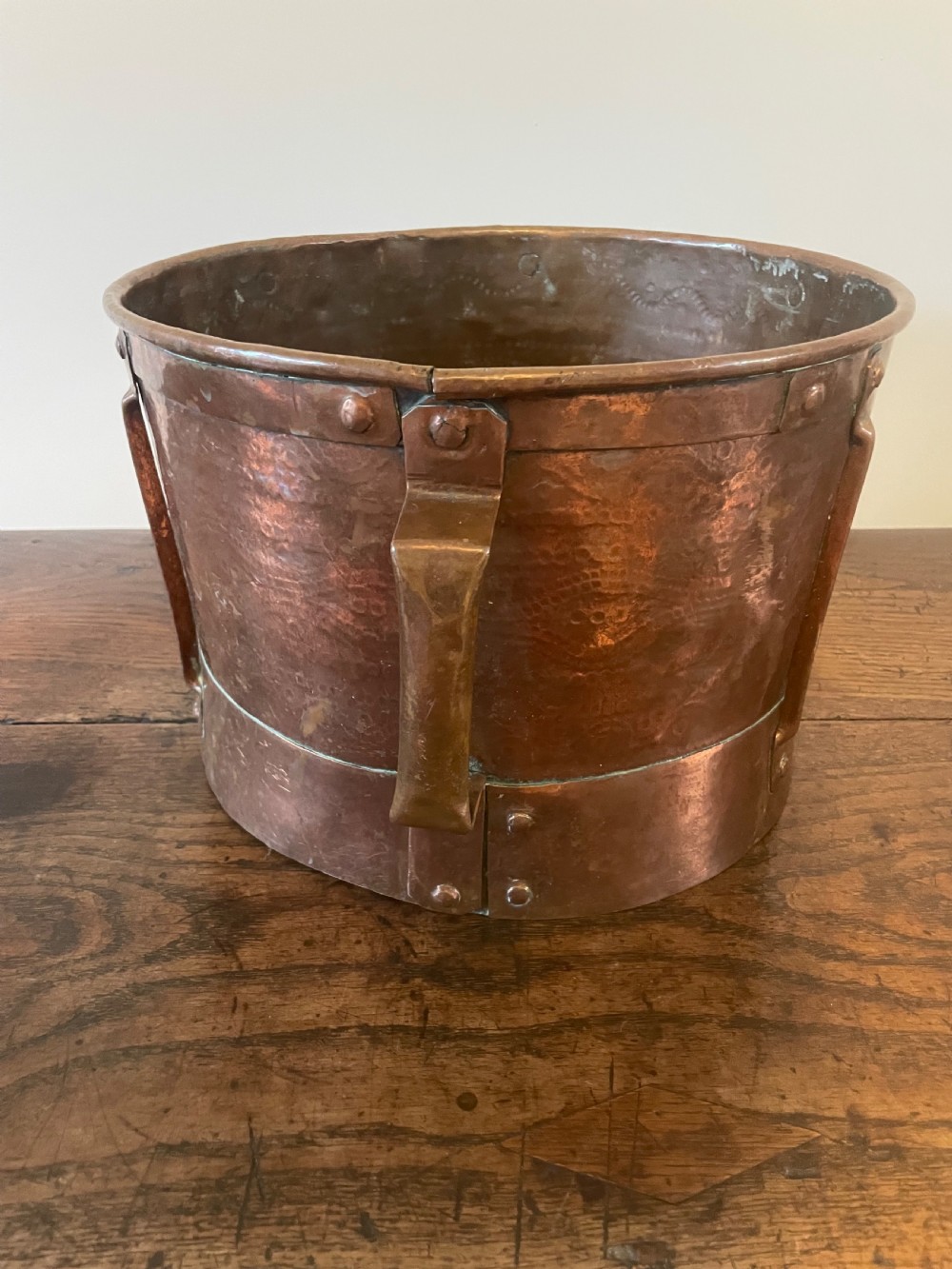 Nineteenth-century hand-hammered copper ferrat bucket featuring riveted vertical support straps and twin side handles. View VIII