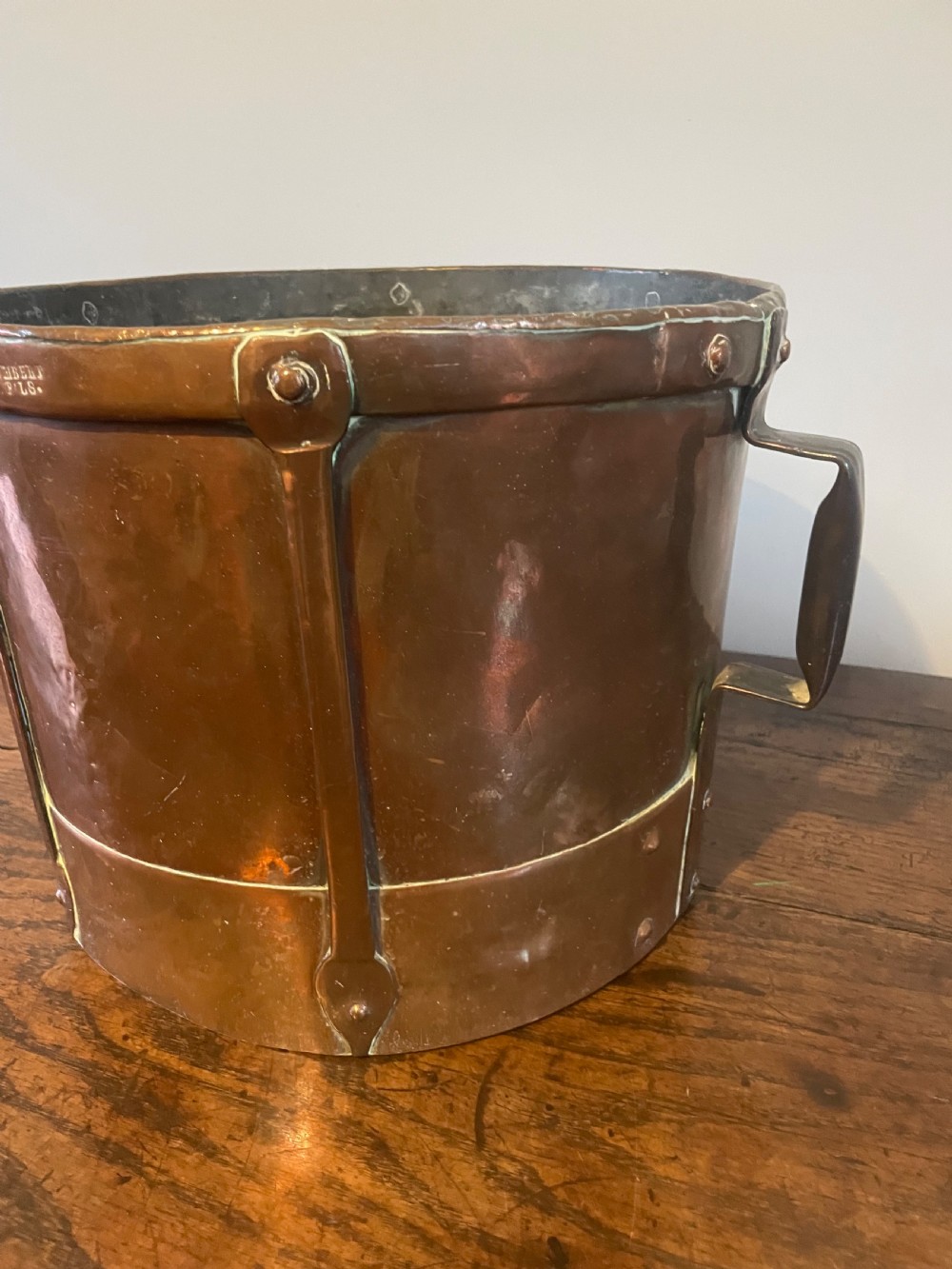 A 19th-century French cylindrical copper bucket featuring riveted vertical reinforcing bands, dual side handles, and a stamped makers mark. View II