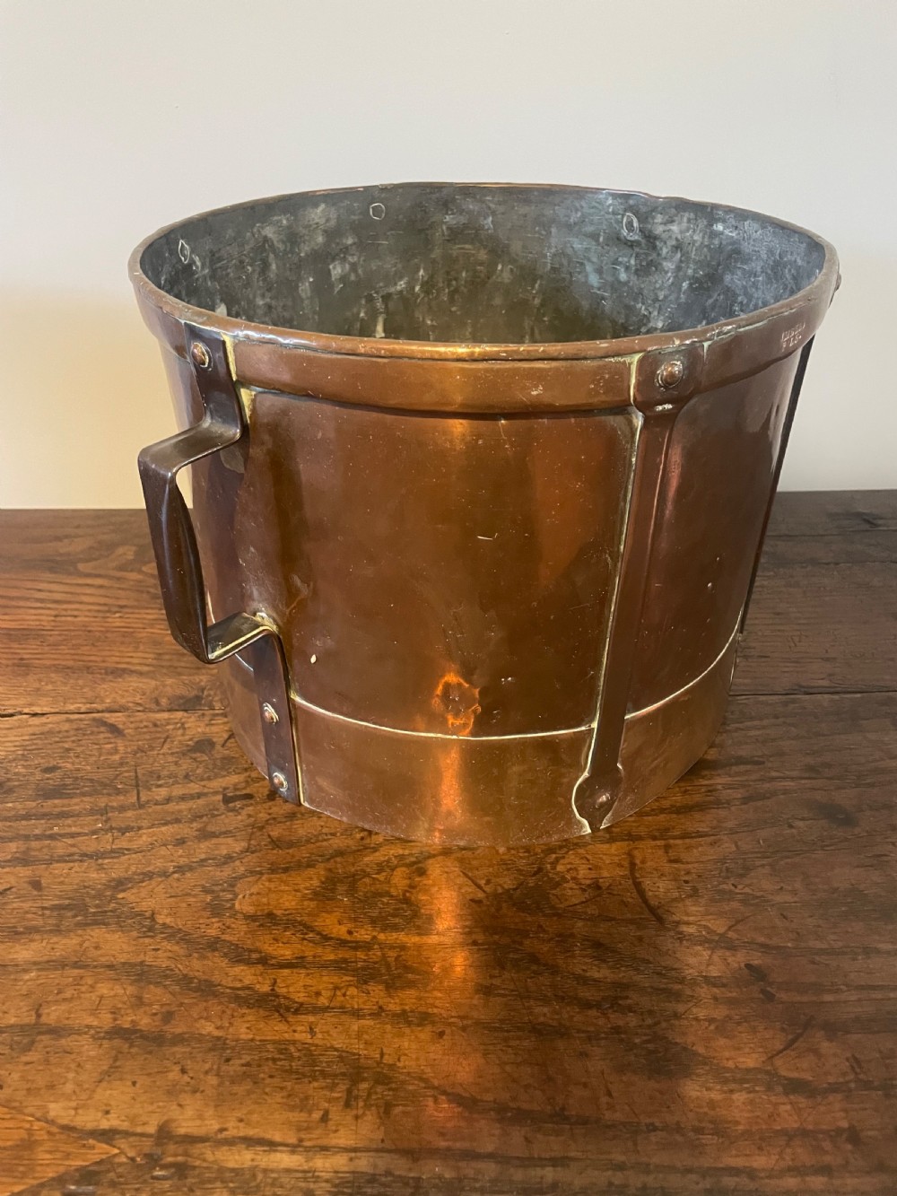A 19th-century French cylindrical copper bucket featuring riveted vertical reinforcing bands, dual side handles, and a stamped makers mark. View V