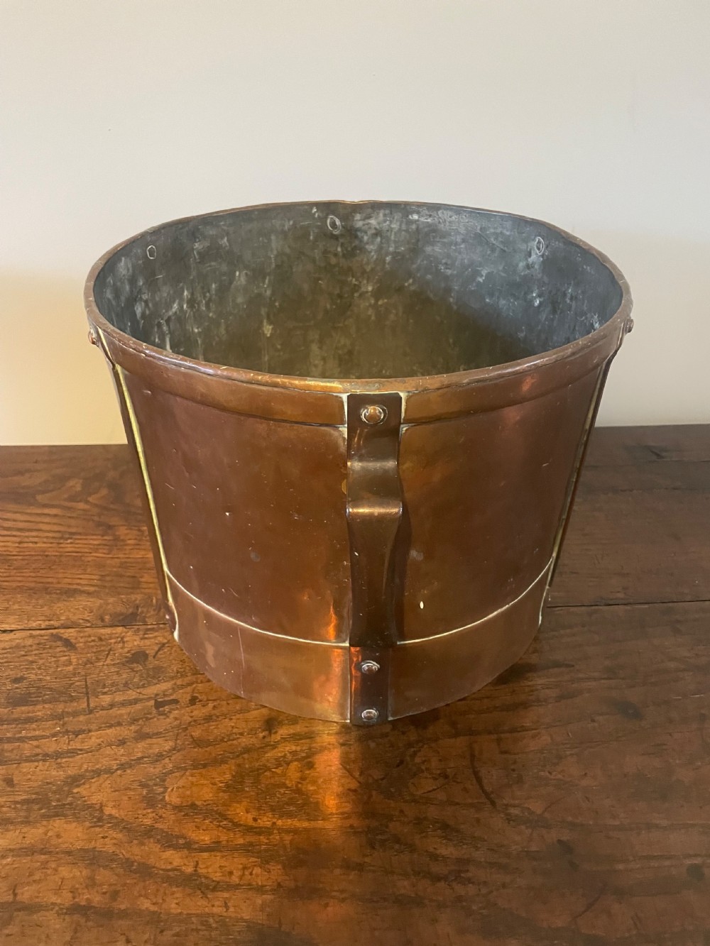 A 19th-century French cylindrical copper bucket featuring riveted vertical reinforcing bands, dual side handles, and a stamped makers mark. View VI