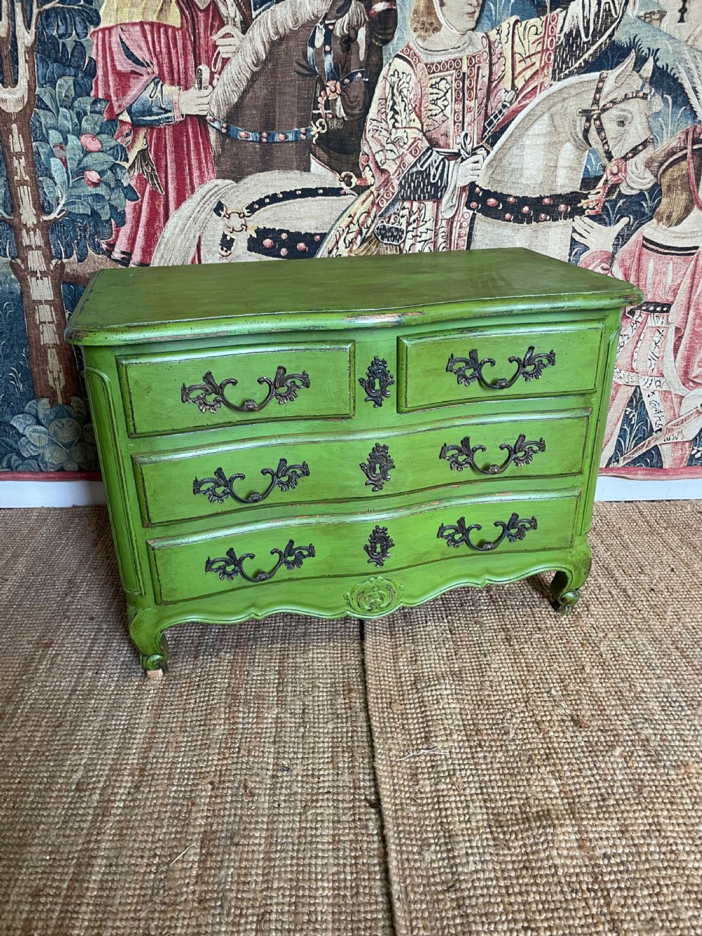 A green painted wooden commode chest of drawers featuring curved cabriole legs and brass hardware.