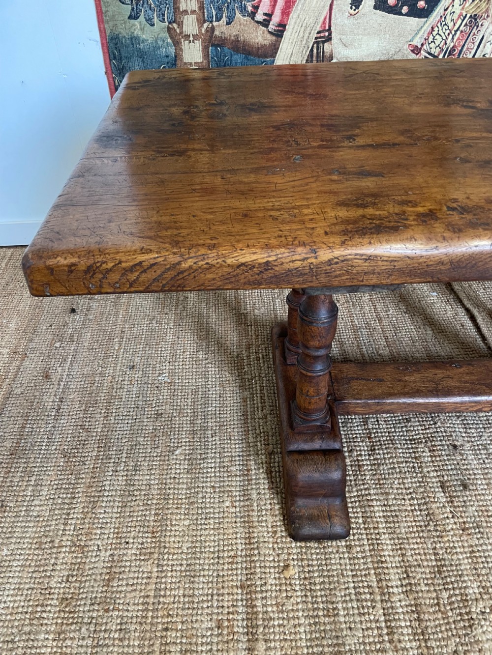 A long rectangular wooden refectory table featuring a plank top and turned leg supports joined by a low stretcher. View IX