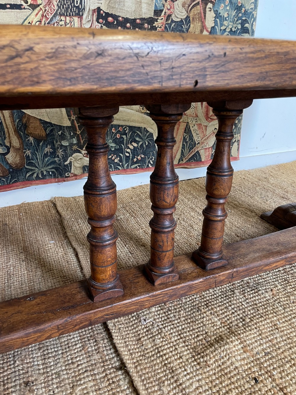 A long rectangular wooden refectory table featuring a plank top and turned leg supports joined by a low stretcher. View XI