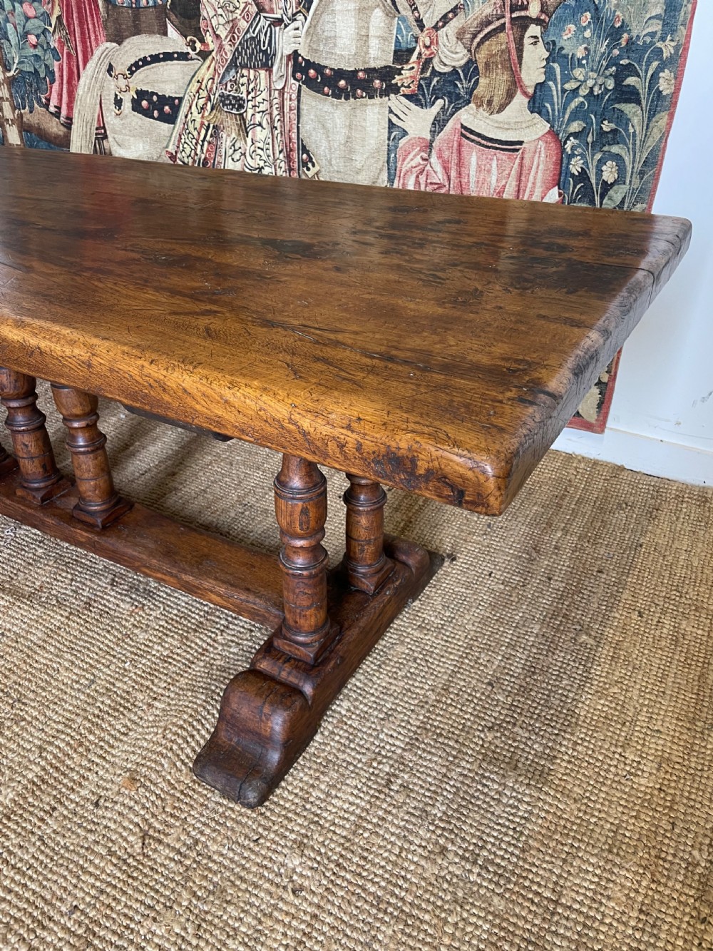 A long rectangular wooden refectory table featuring a plank top and turned leg supports joined by a low stretcher. View XII