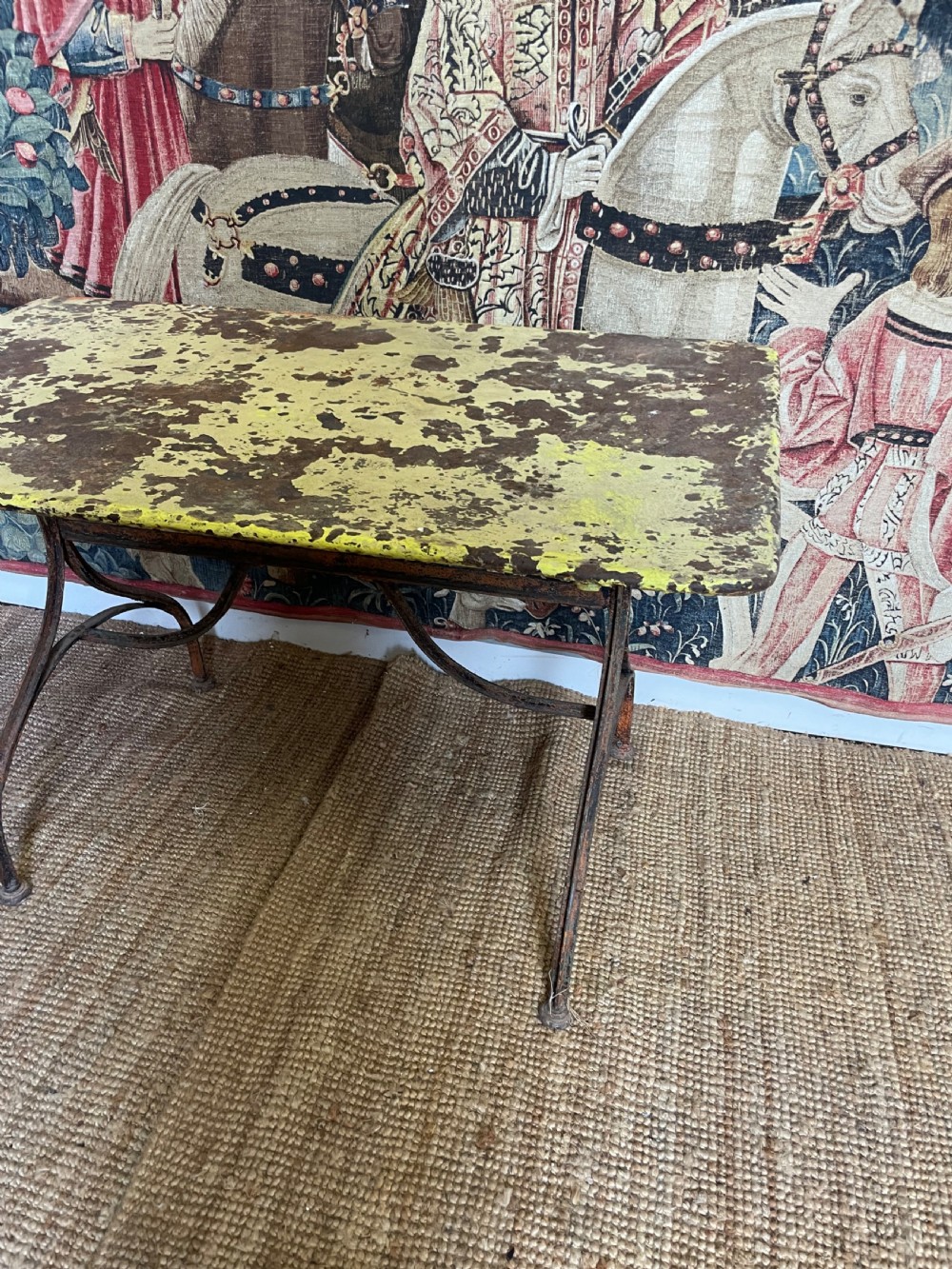 An antique rectangular metal garden table with a distressed yellow painted top and curved iron legs. View II