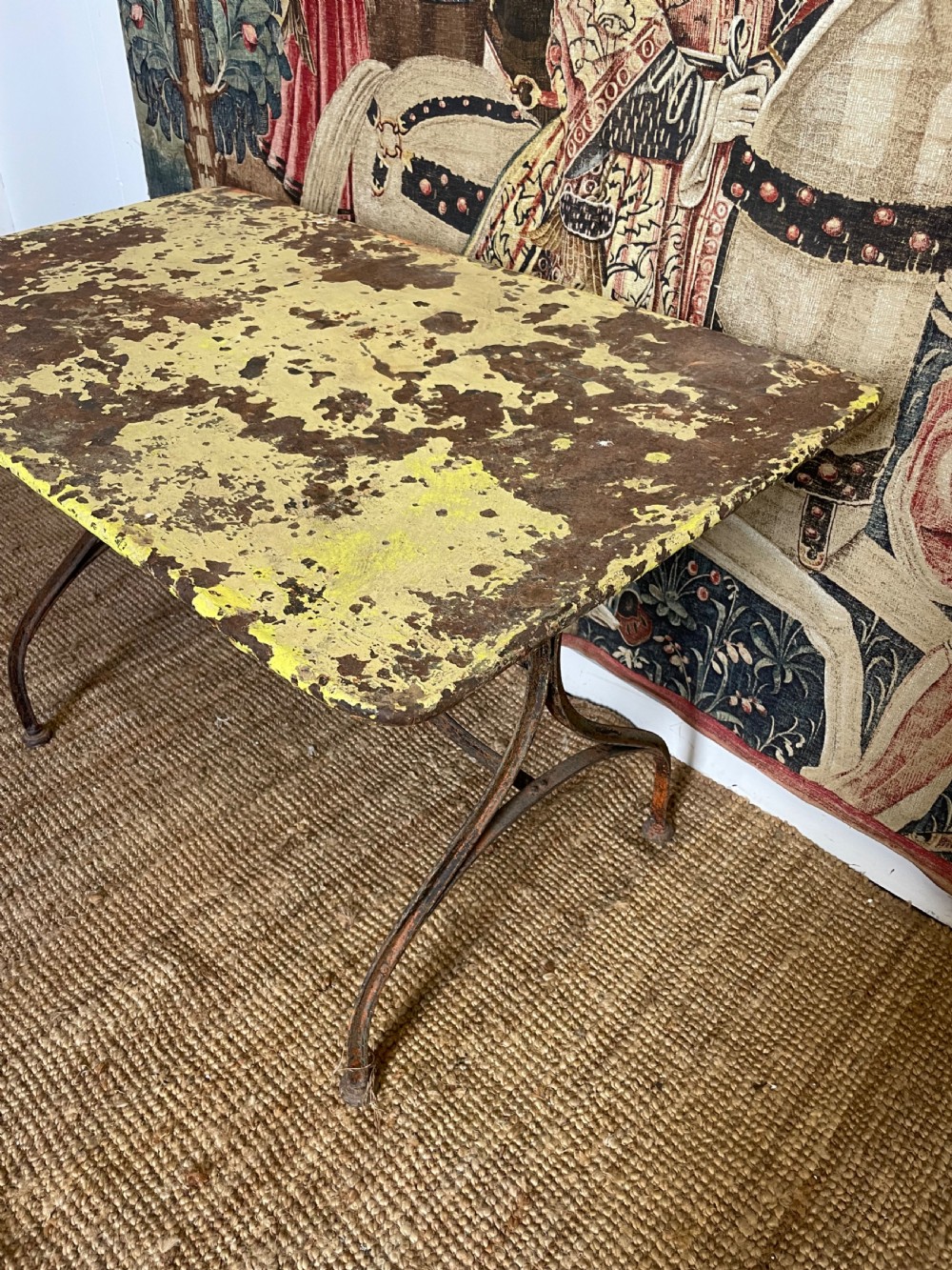 An antique rectangular metal garden table with a distressed yellow painted top and curved iron legs. View III