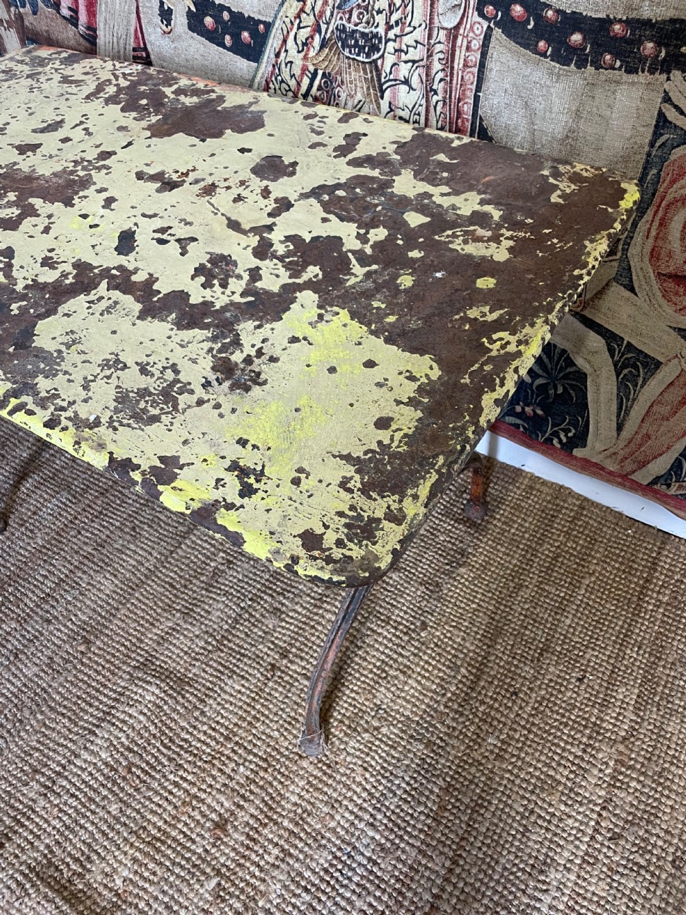 An antique rectangular metal garden table with a distressed yellow painted top and curved iron legs. View VI