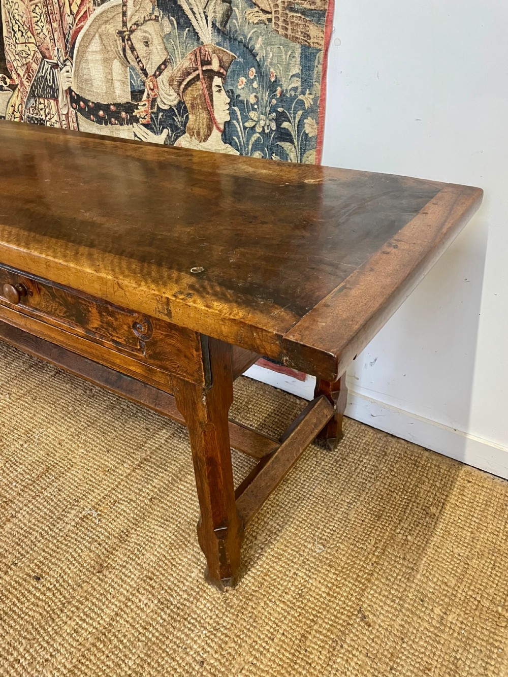 An elongated antique walnut console table featuring three drawers with brass hardware and low stretcher supports. View II