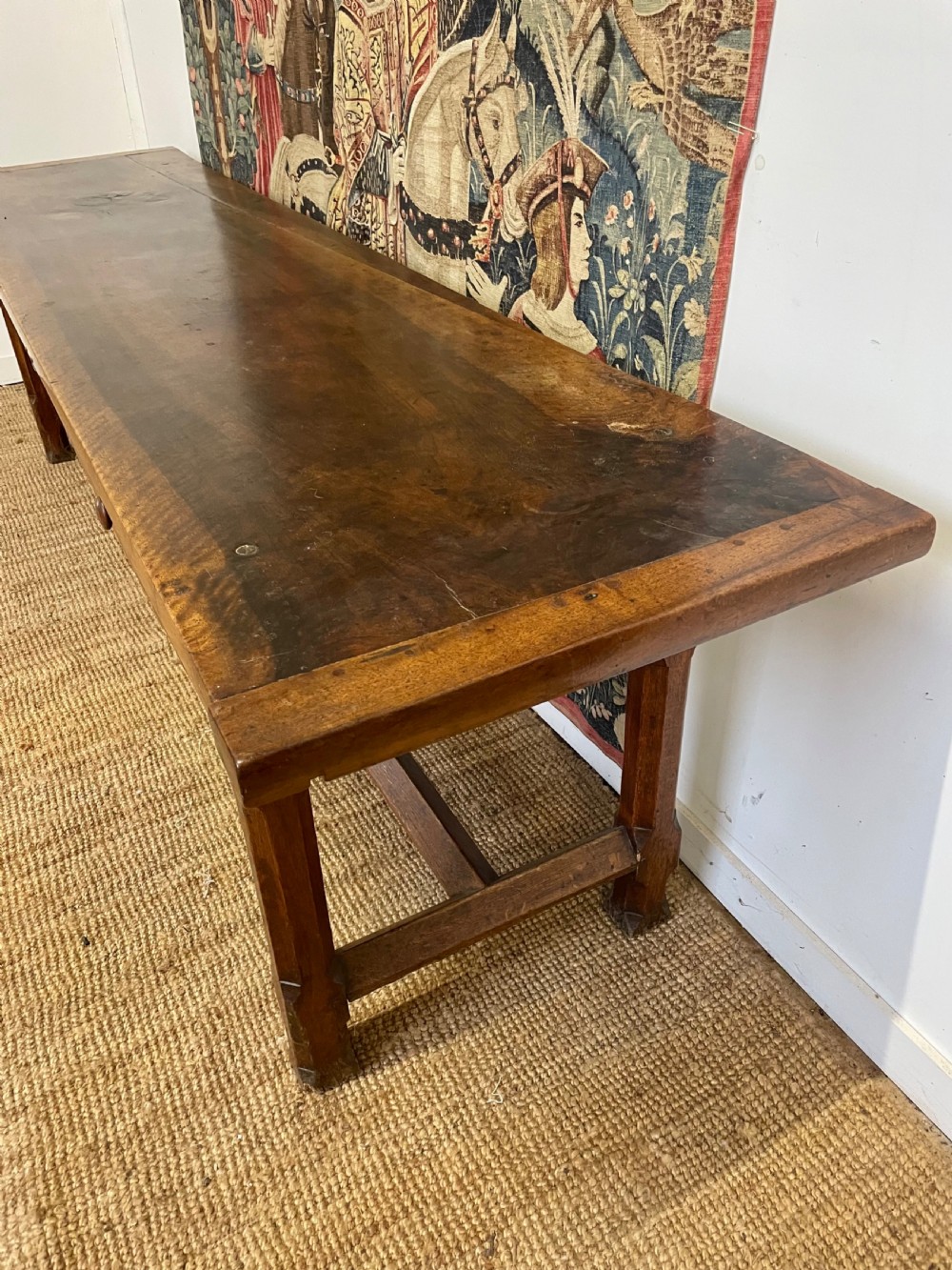 An elongated antique walnut console table featuring three drawers with brass hardware and low stretcher supports. View III