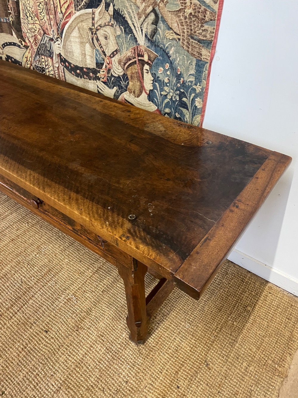 An elongated antique walnut console table featuring three drawers with brass hardware and low stretcher supports. View V