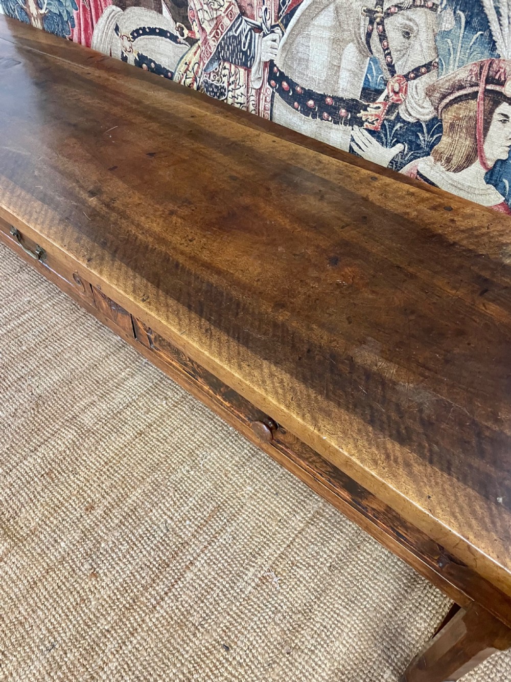 An elongated antique walnut console table featuring three drawers with brass hardware and low stretcher supports. View VII