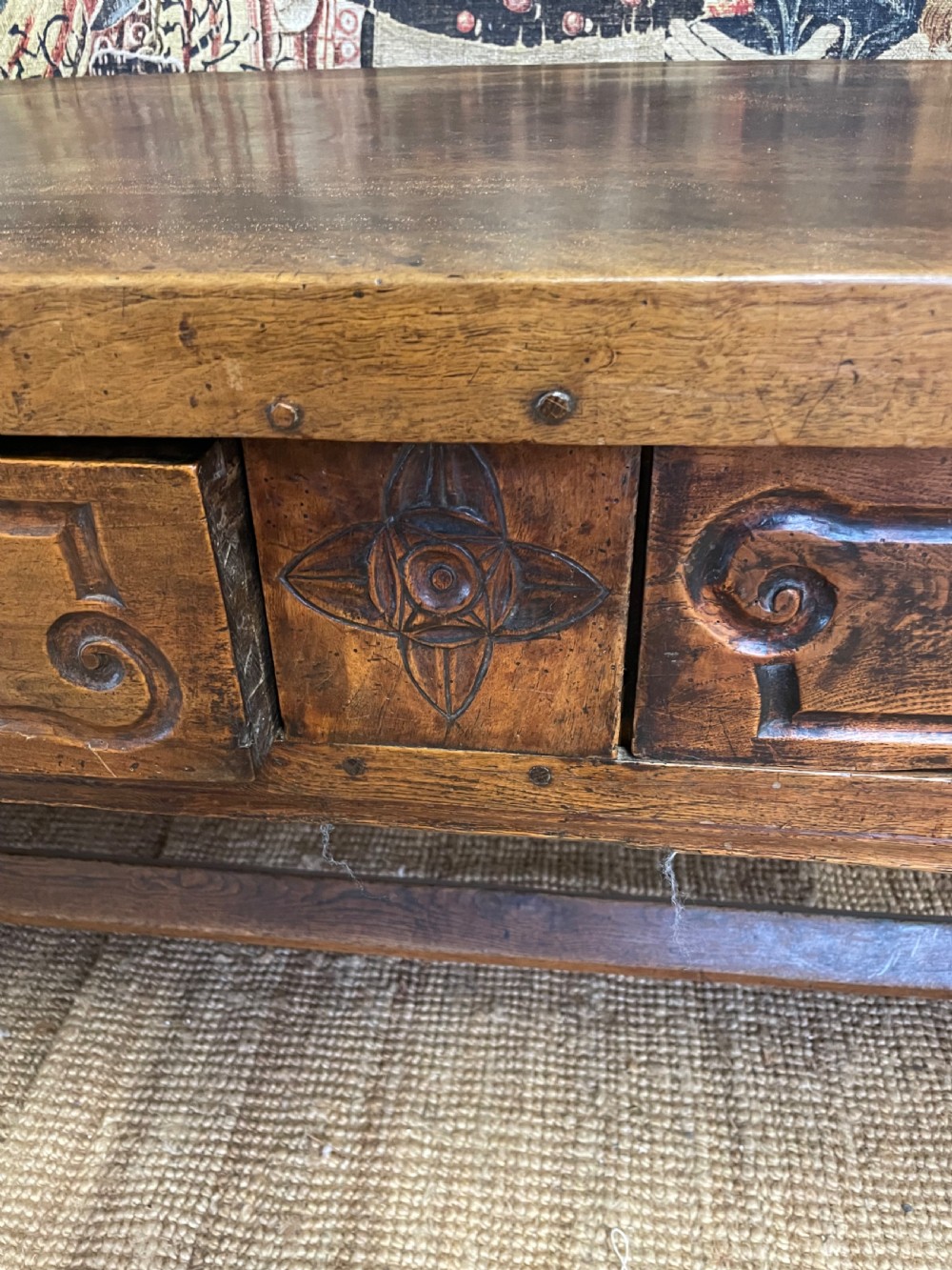 An elongated antique walnut console table featuring three drawers with brass hardware and low stretcher supports. View XI