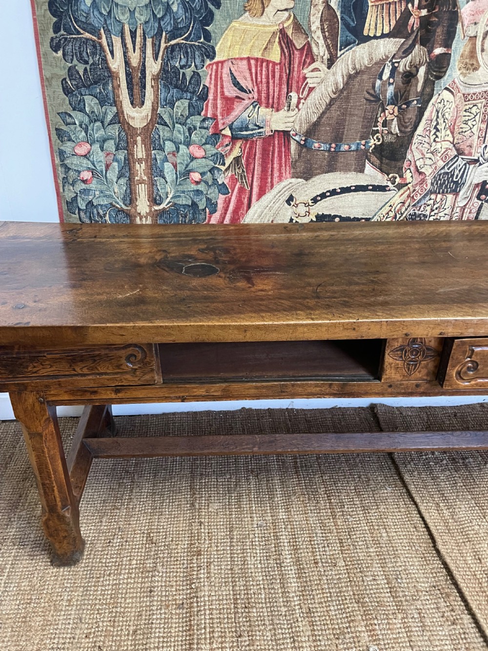 An elongated antique walnut console table featuring three drawers with brass hardware and low stretcher supports. View XIII