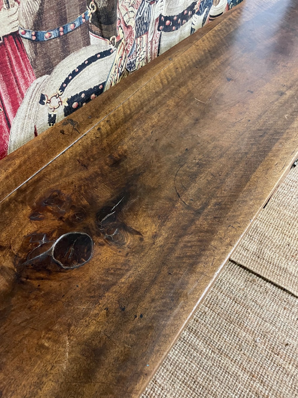 An elongated antique walnut console table featuring three drawers with brass hardware and low stretcher supports. View XVII