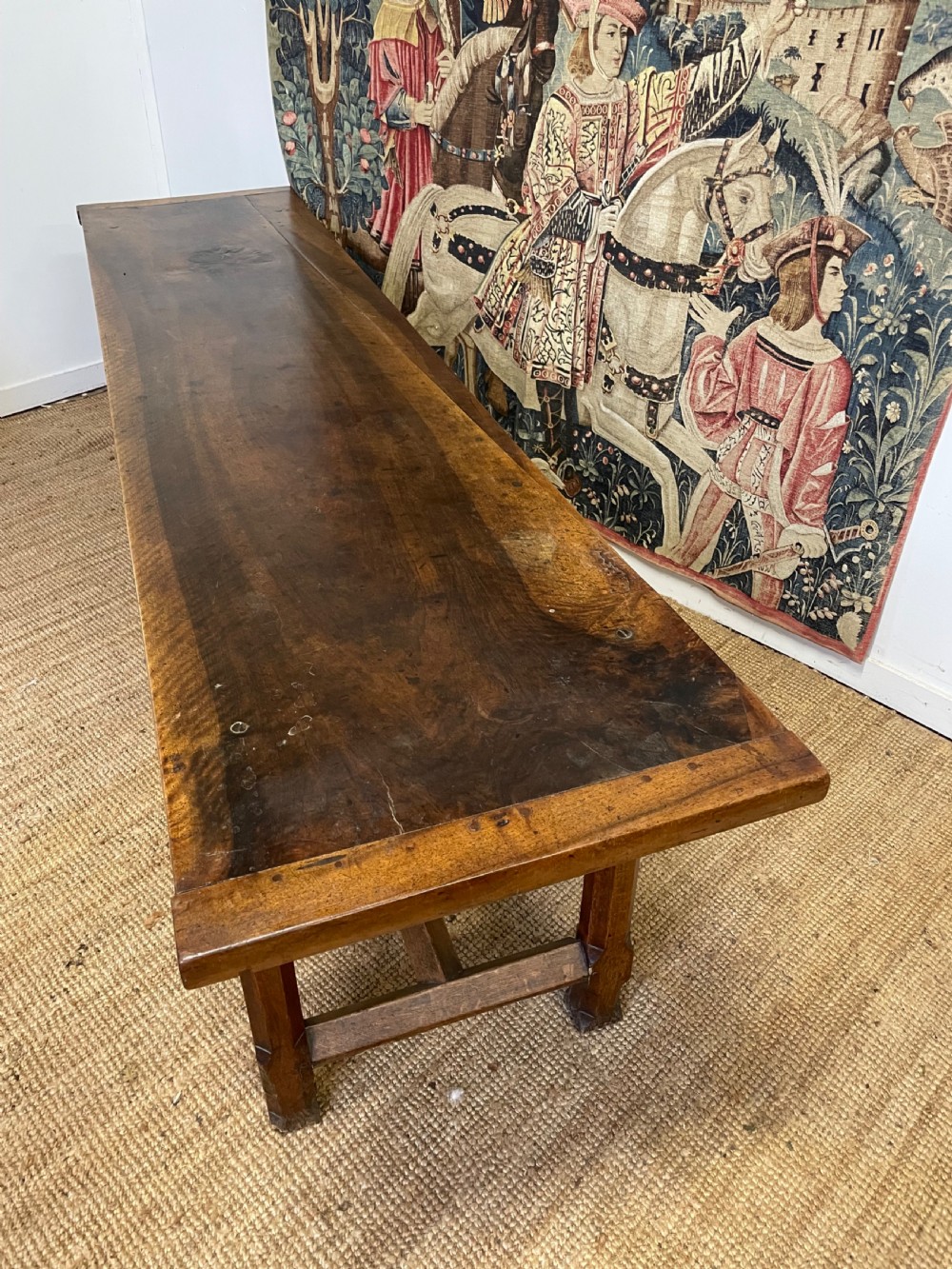 An elongated antique walnut console table featuring three drawers with brass hardware and low stretcher supports. View XXI