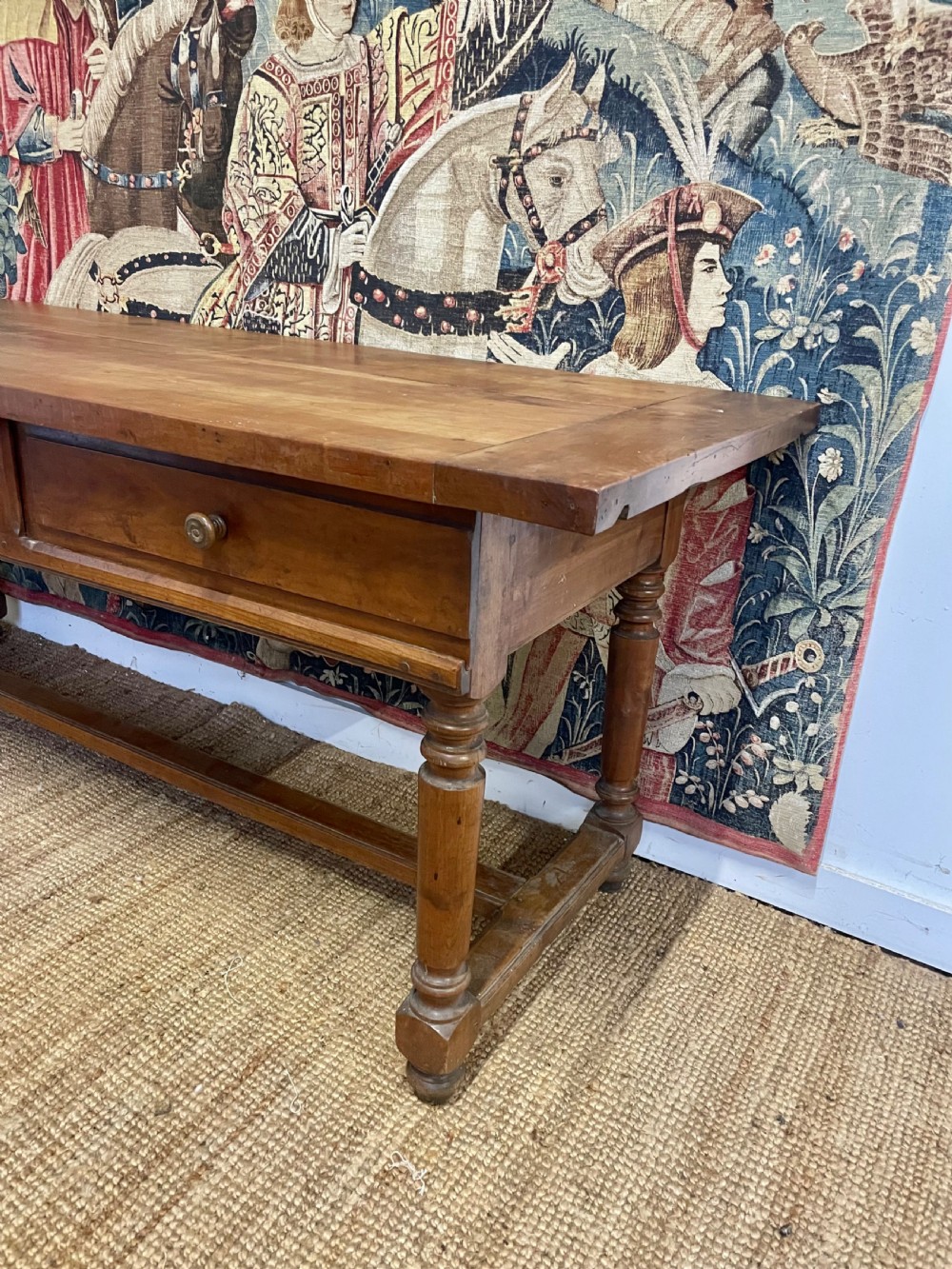 A long rectangular antique cherrywood console table featuring three frieze drawers with small brass knobs and turned legs connected by a low stretcher. View II
