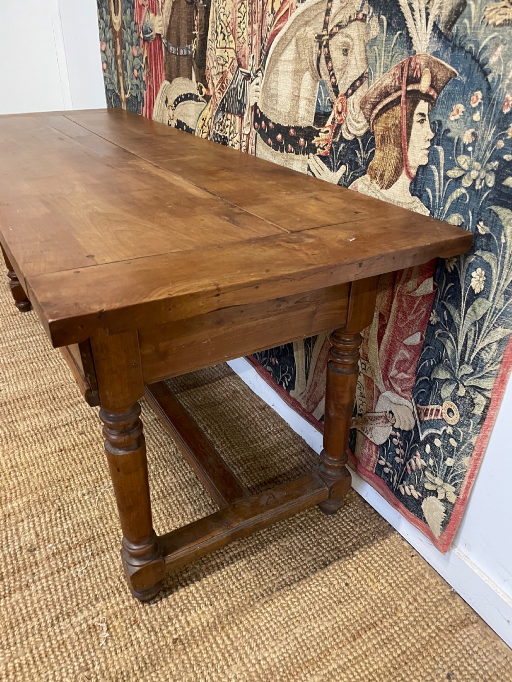 A long rectangular antique cherrywood console table featuring three frieze drawers with small brass knobs and turned legs connected by a low stretcher. View III