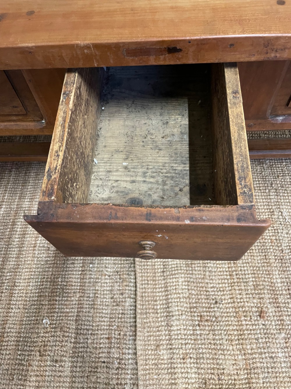 A long rectangular antique cherrywood console table featuring three frieze drawers with small brass knobs and turned legs connected by a low stretcher. View VII