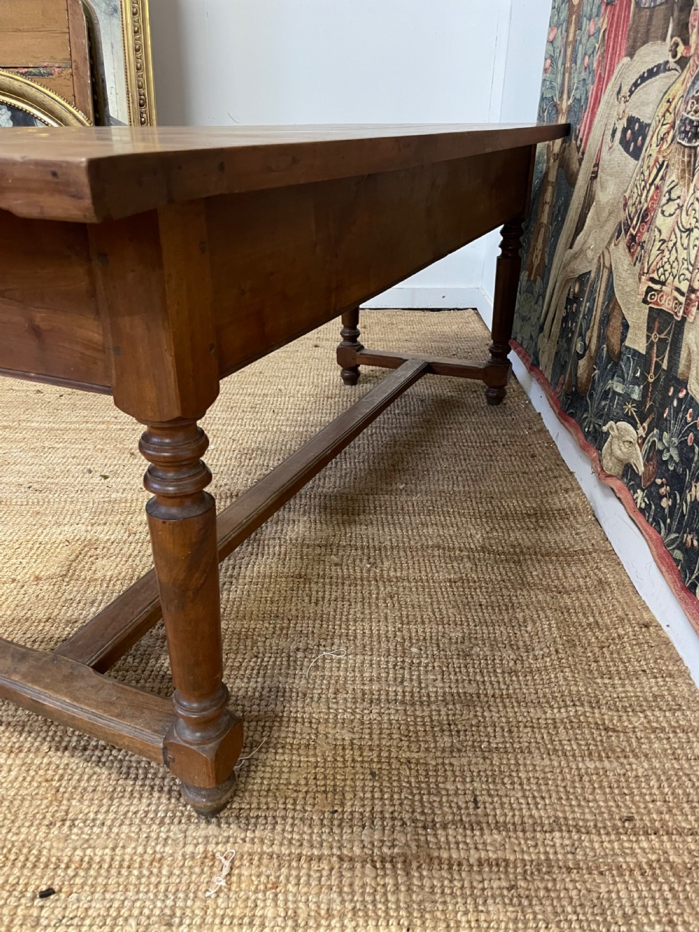 A long rectangular antique cherrywood console table featuring three frieze drawers with small brass knobs and turned legs connected by a low stretcher. View XI