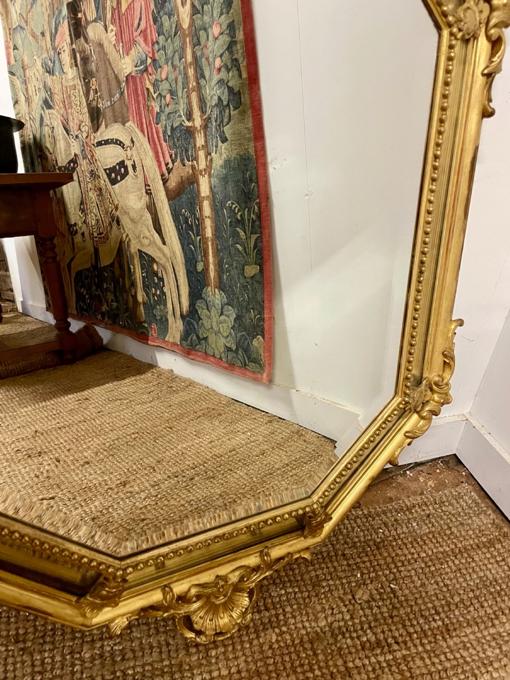 An ornate Napoleon III gilt cushion framed wall mirror with bevelled glass and carved scrollwork details. View V