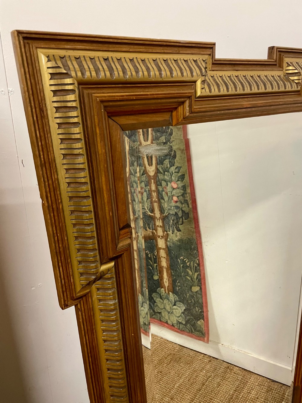 A rectangular walnut wall mirror featuring stepped architectural corner mouldings and carved parcel gilt accent trim. View II