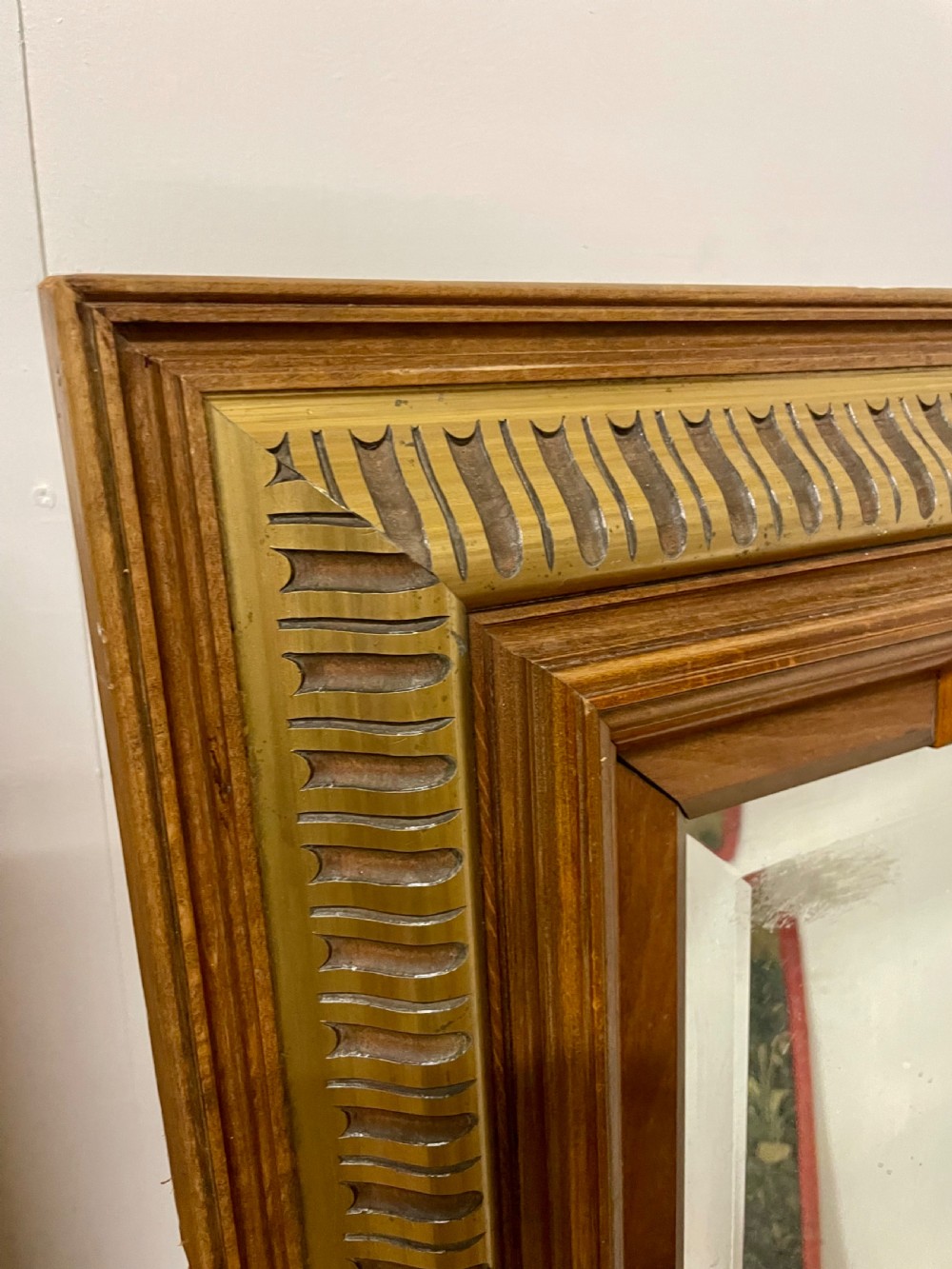 A rectangular walnut wall mirror featuring stepped architectural corner mouldings and carved parcel gilt accent trim. View V