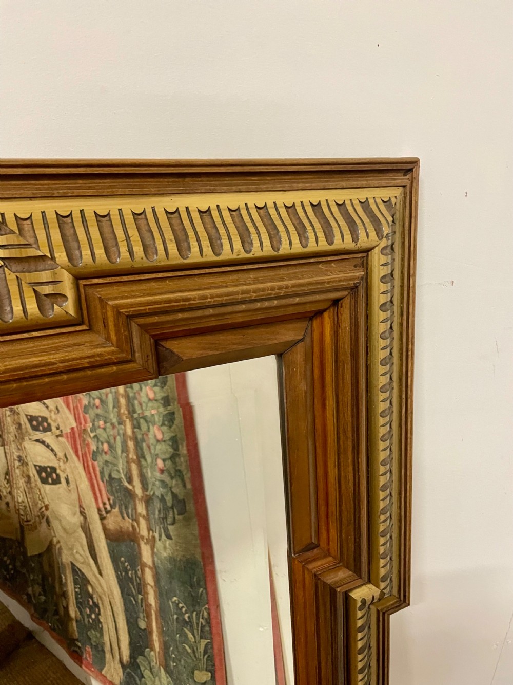 A rectangular walnut wall mirror featuring stepped architectural corner mouldings and carved parcel gilt accent trim. View VI