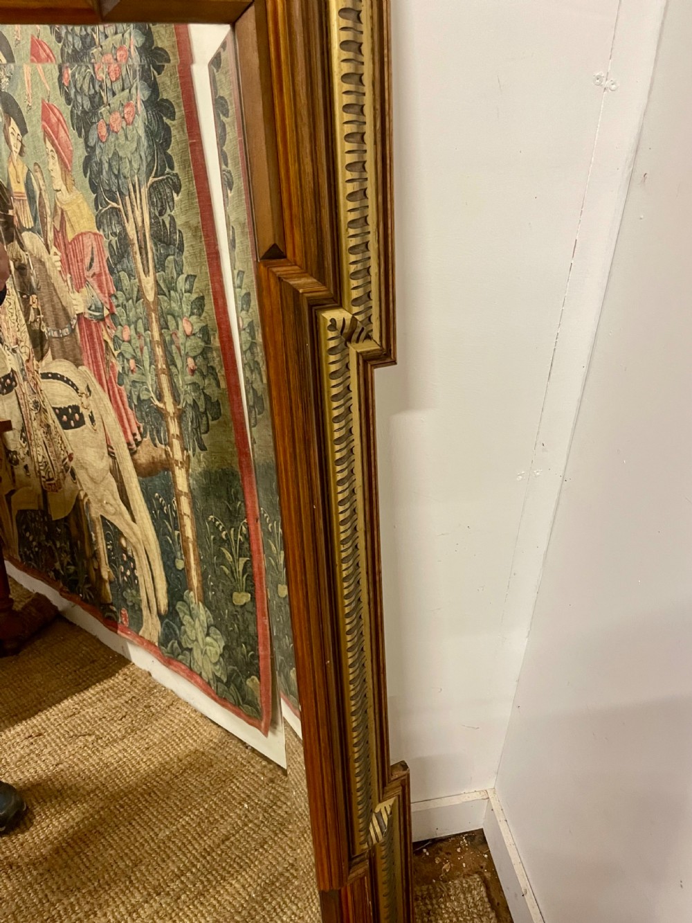 A rectangular walnut wall mirror featuring stepped architectural corner mouldings and carved parcel gilt accent trim. View VII
