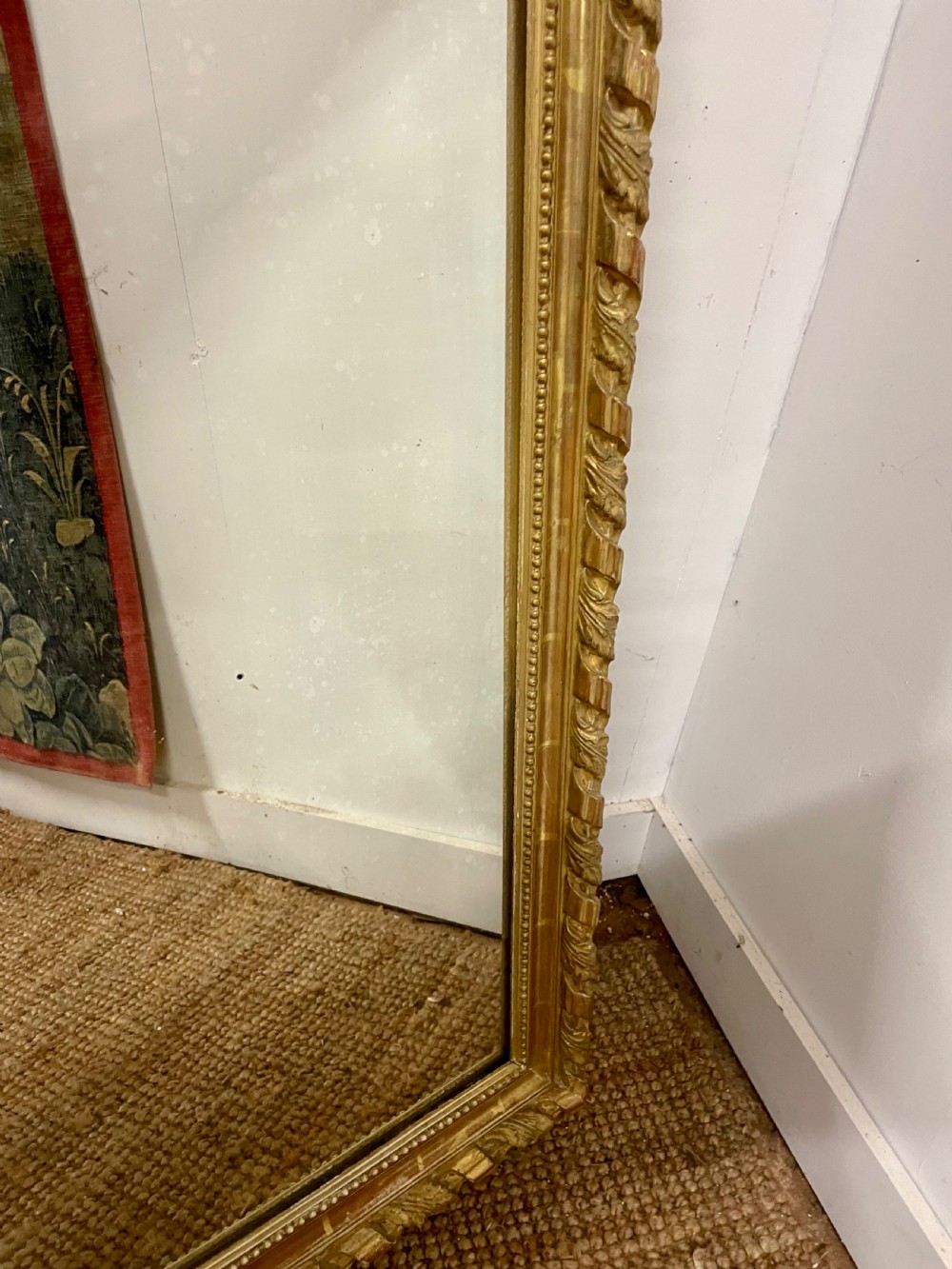 A late nineteenth-century gilded wall mirror featuring an arched top, carved shell cresting, and foliate moulding on the frame. View V