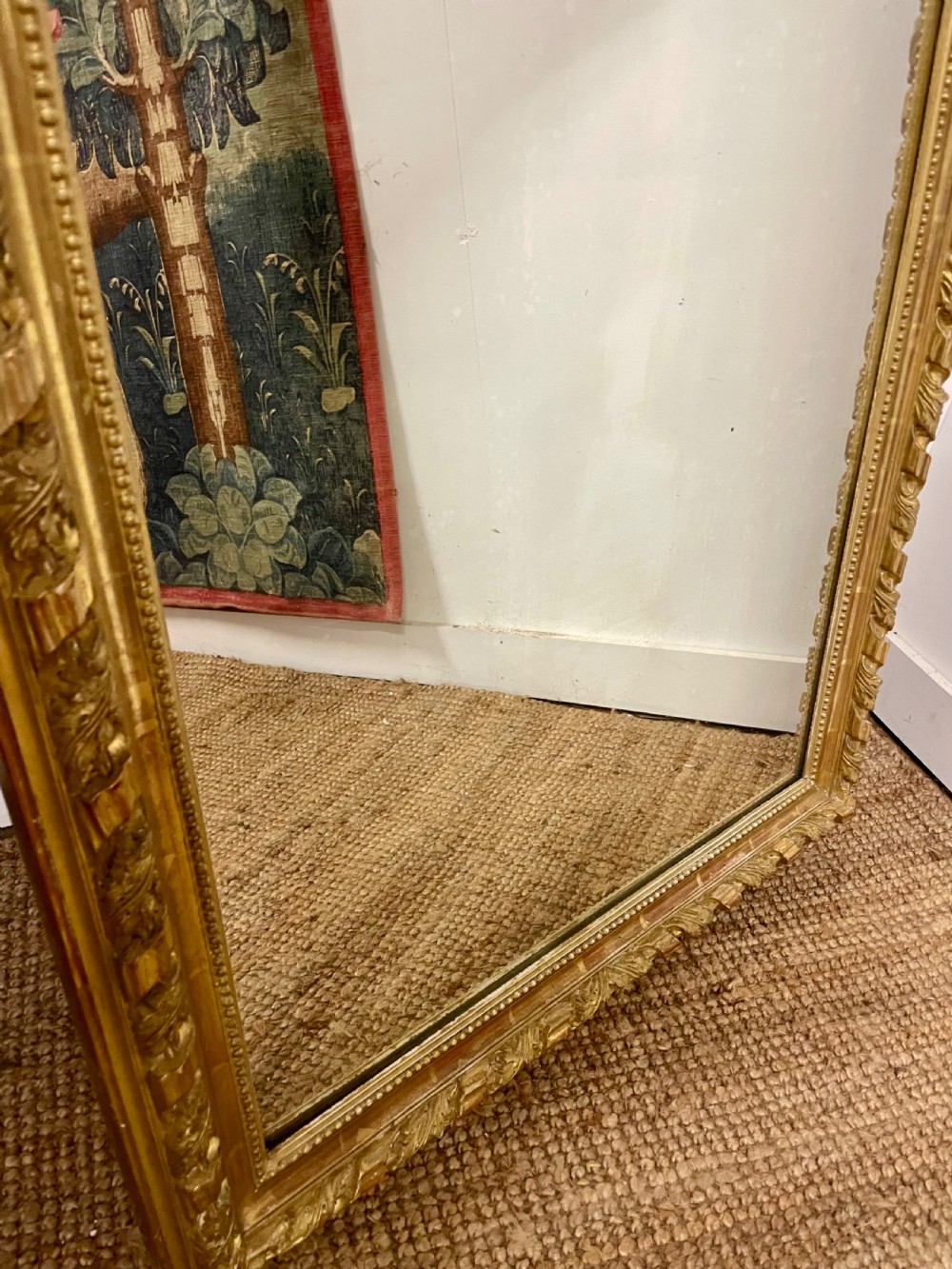 A late nineteenth-century gilded wall mirror featuring an arched top, carved shell cresting, and foliate moulding on the frame. View VI