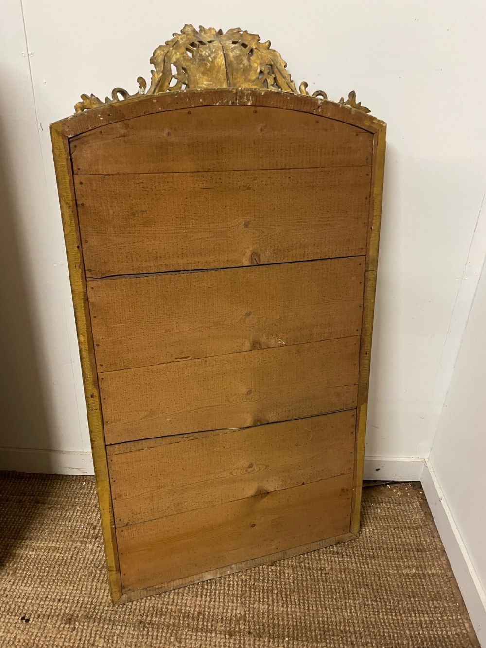 A late nineteenth-century gilded wall mirror featuring an arched top, carved shell cresting, and foliate moulding on the frame. View XII