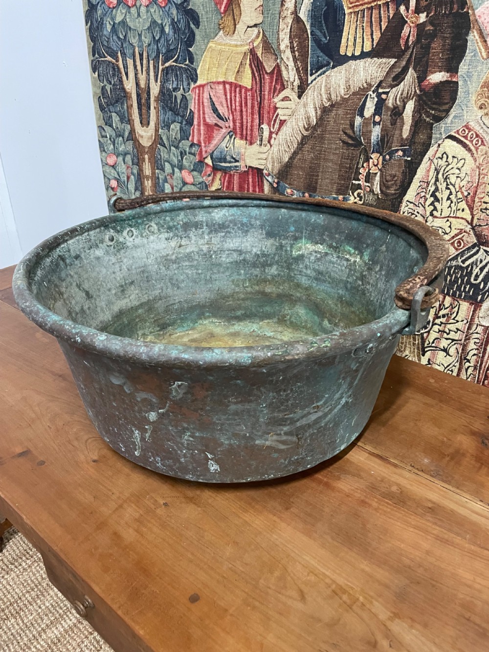 A 19th-century round copper log bin featuring a natural green verdigris patina and a heavy wrought iron swing handle. View II