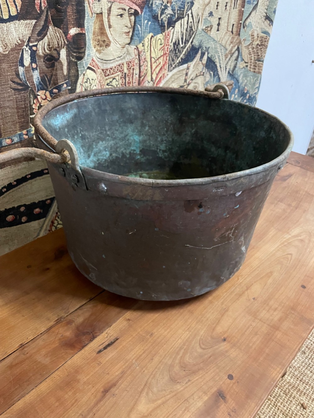 A circular 19th-century copper vessel with a verdigris interior, patinated copper exterior, rolled rim, and wrought iron side handles. View V