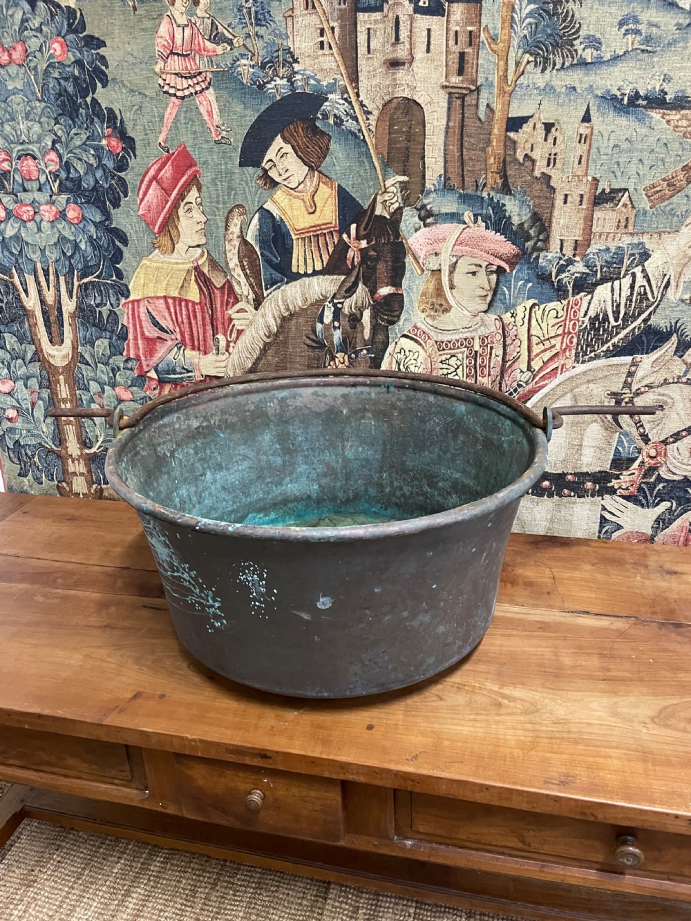 A large 19th-century copper log bin featuring wrought iron side handles and a verdigris green interior patina.