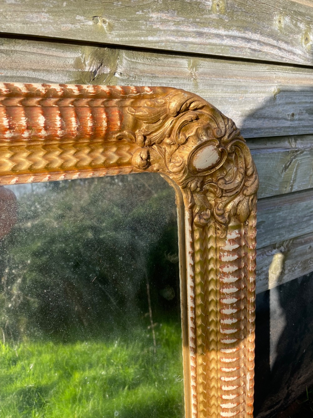 A 19th-century rectangular wall mirror featuring an arched upper frame with detailed giltwood moulding, corner cartouches, and patinated mirror glass. View II