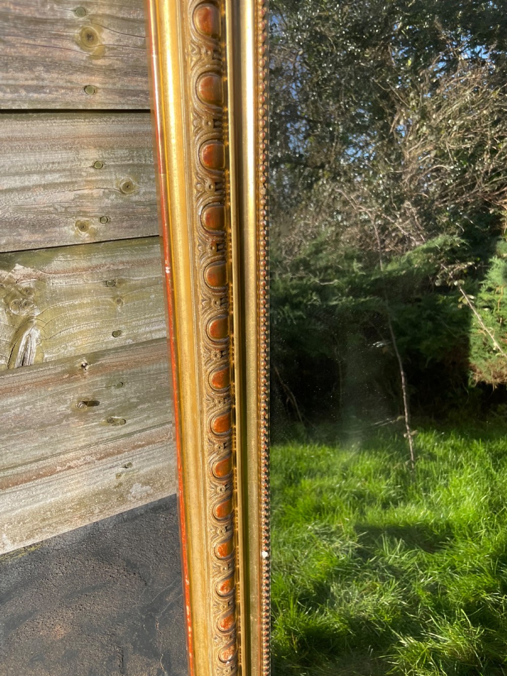 A large 19th-century gilded overmantle mirror featuring an arched top frame adorned with a carved floral shell crest and beaded inner moulding. View IV