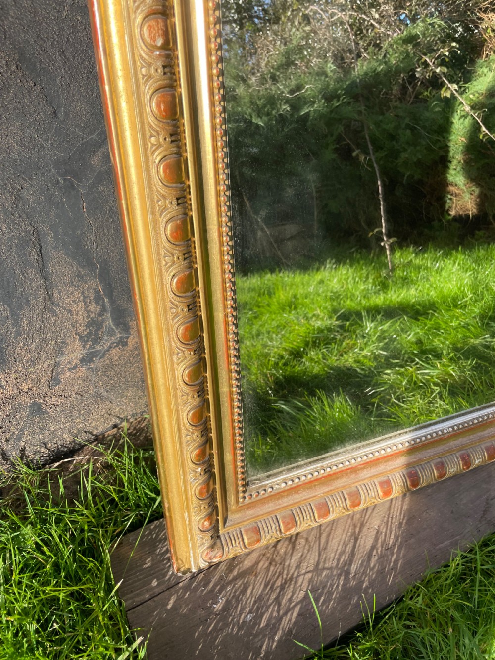 A large 19th-century gilded overmantle mirror featuring an arched top frame adorned with a carved floral shell crest and beaded inner moulding. View V