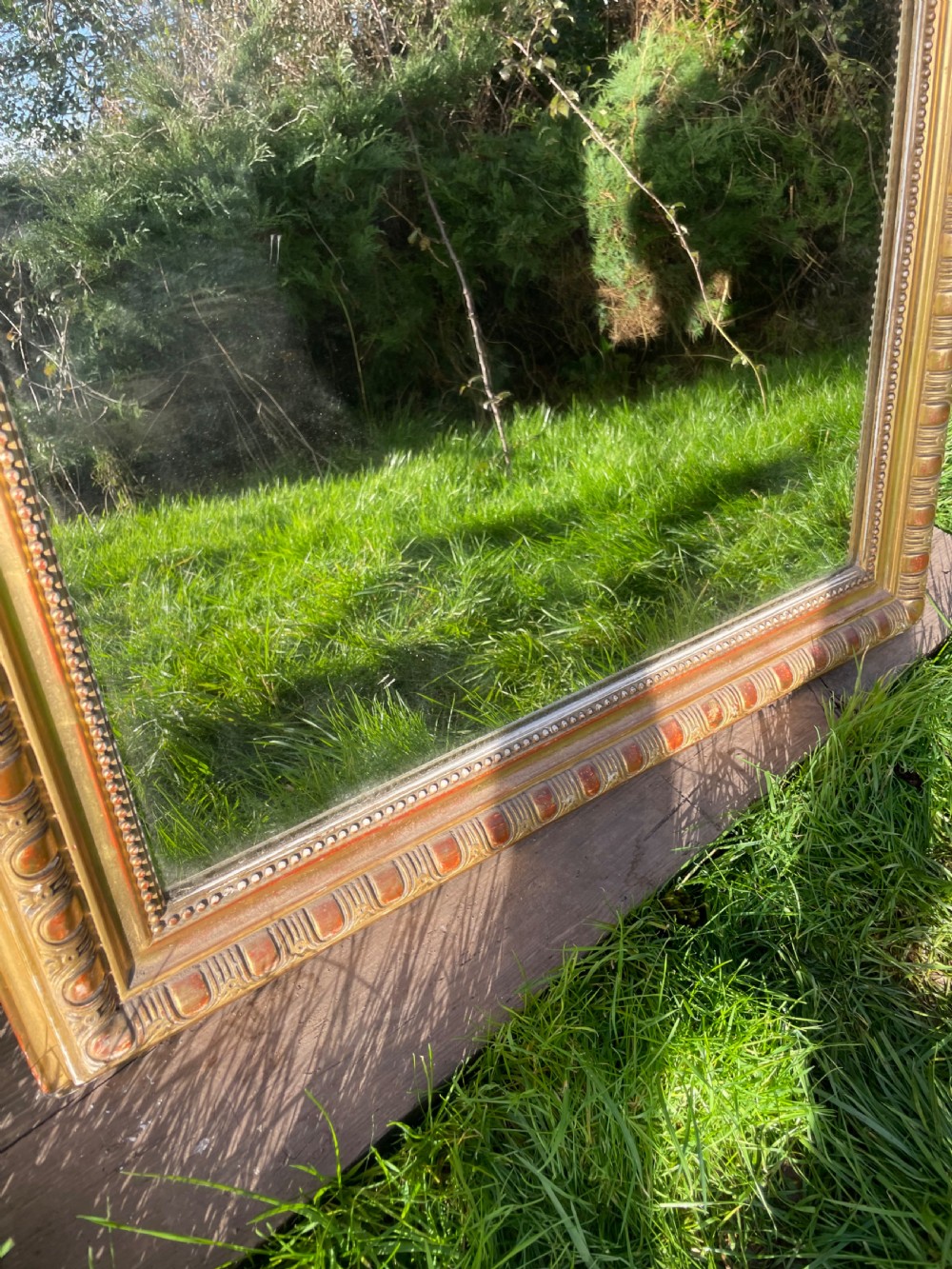 A large 19th-century gilded overmantle mirror featuring an arched top frame adorned with a carved floral shell crest and beaded inner moulding. View VI