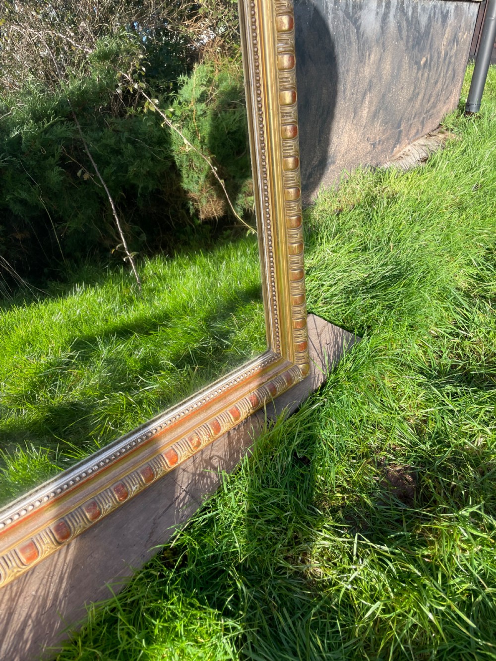 A large 19th-century gilded overmantle mirror featuring an arched top frame adorned with a carved floral shell crest and beaded inner moulding. View VII